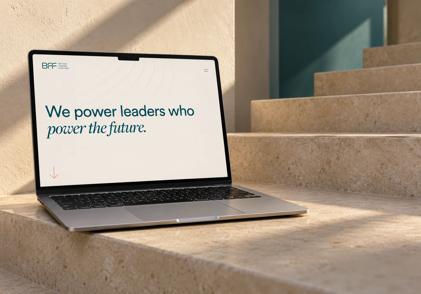 Better Faster Further homepage on a silver MacBook on a limestone staircase.