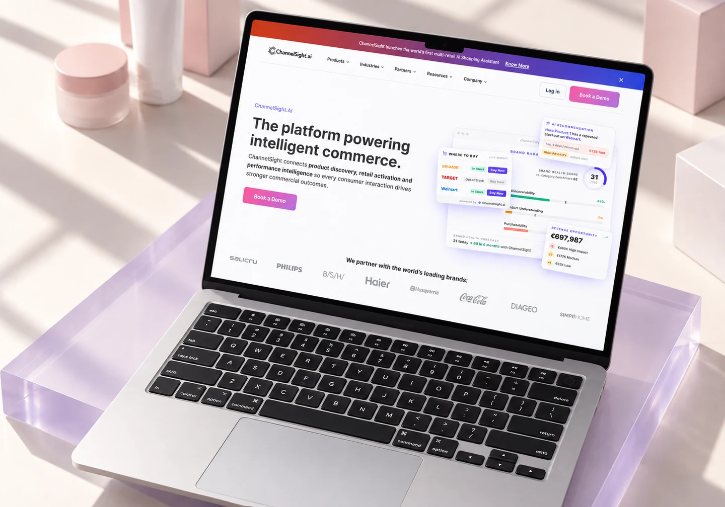 ChannelSight homepage on a silver MacBook on lavender acrylic among retail packaging.